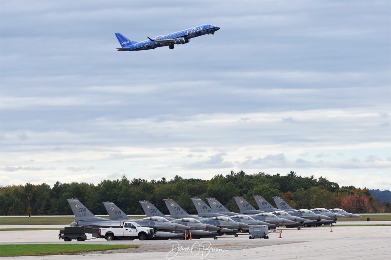 Jet Blue departs Pease while Shaw's F-16 sit on the ramp
